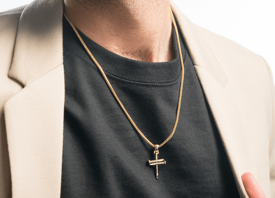 man in beige suit wearing gold jewelry