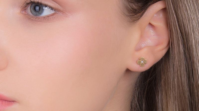 gold earrings with zircons on ear